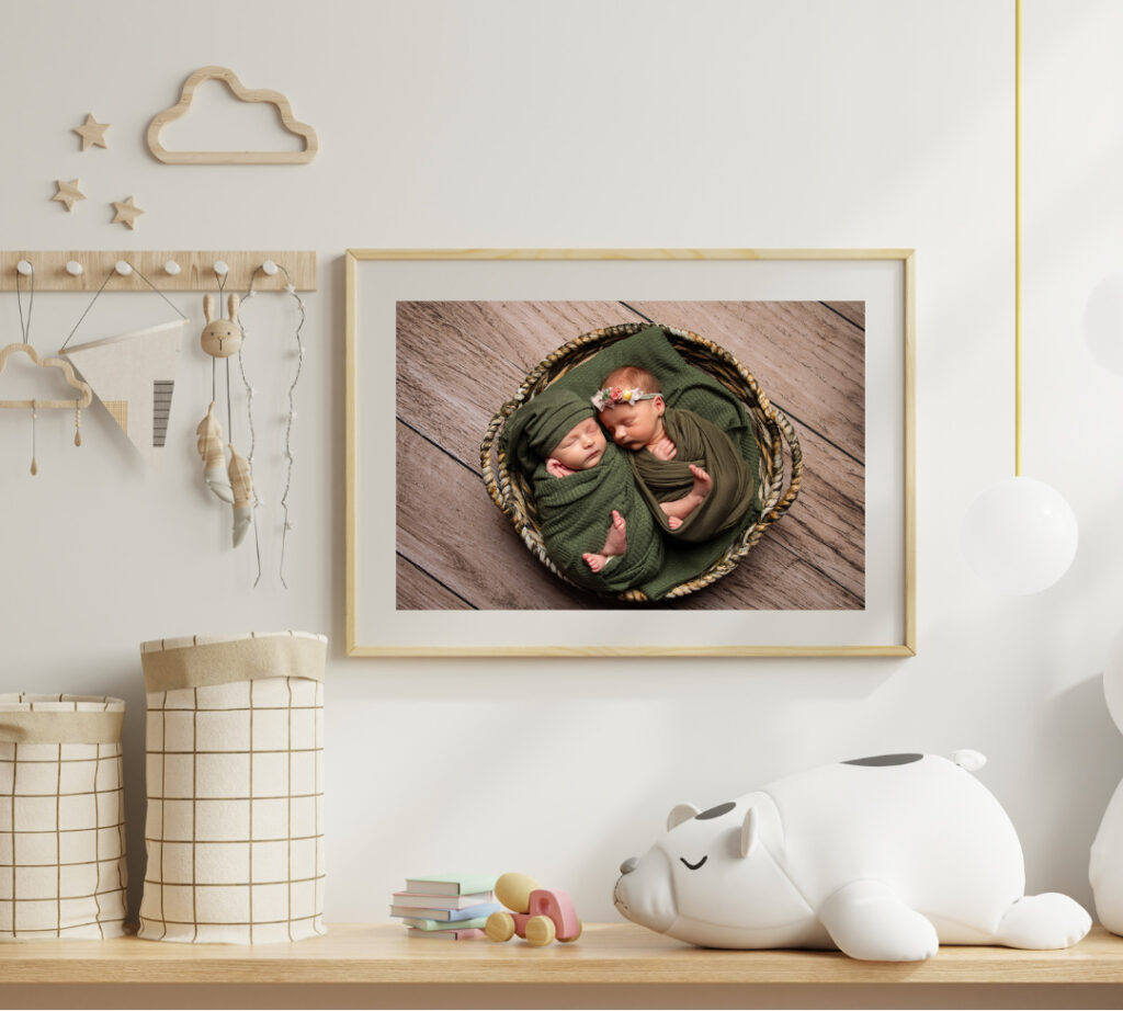 newborn portrait artwork of twins swaddled in green blankets snuggling in a bowl, mocked up to look like the are is in the baby's nursery