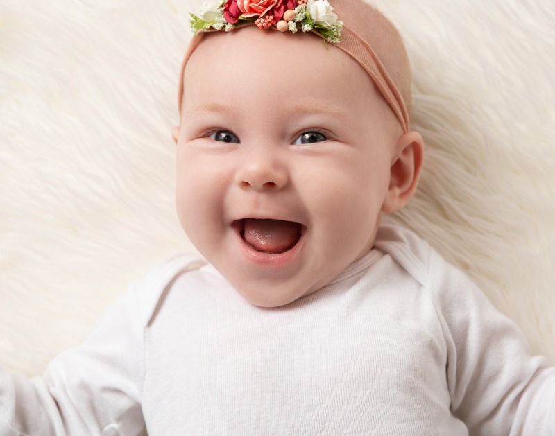 Happy baby girl smiles during her milestone photography session