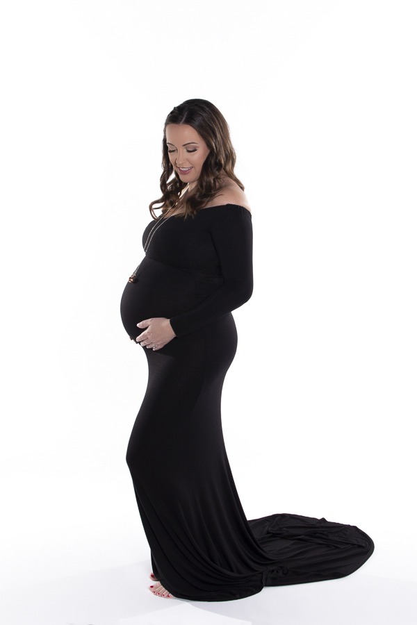 Capturing the Beauty of Motherhood With A Sentimental Pregnancy Gift, Charlotte Maternity Portrait, beautiful mother to be in a black gown on a white background including an angel chime pendant to symbolize baby's Italian heritage