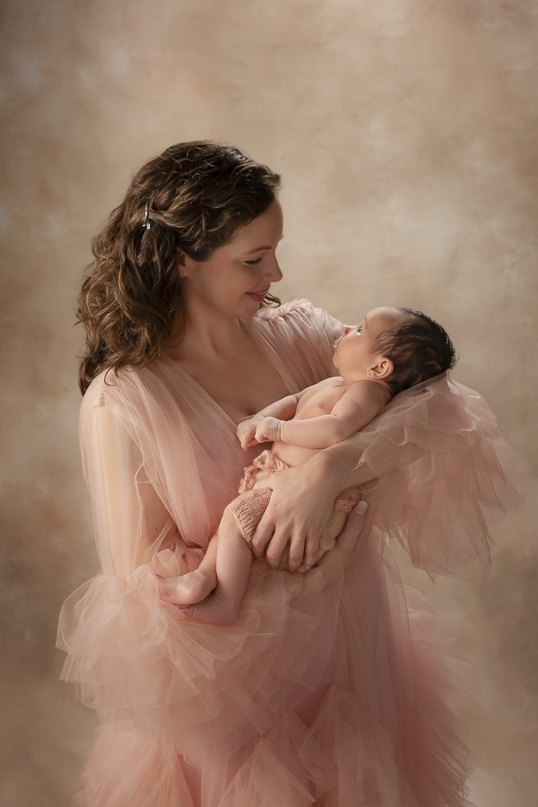 Mom and her beautiful newborn baby during safe newborn session, motherhood photography